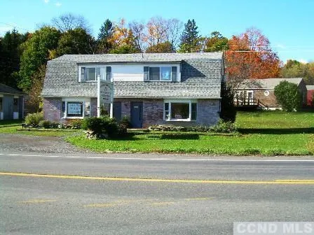 a front view of a house with a garden and plants
