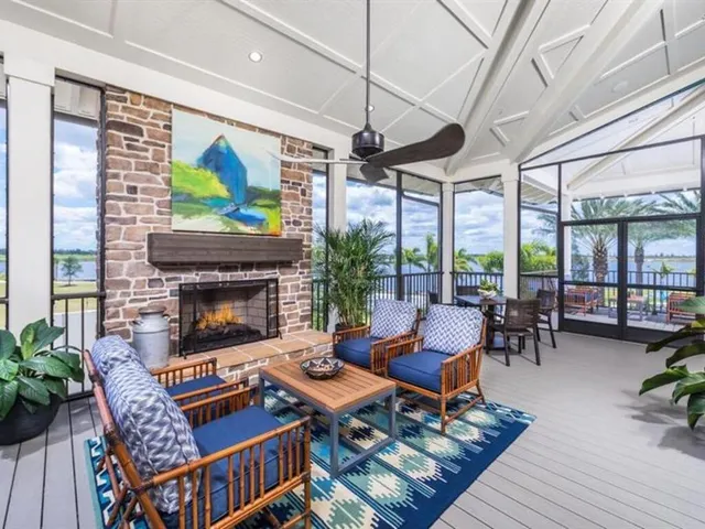 a living room with furniture a fireplace and a floor to ceiling window