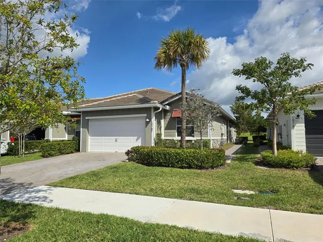a front view of a house with a garden and trees