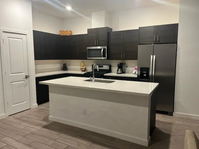 a bathroom with a sink a large mirror and a refrigerator