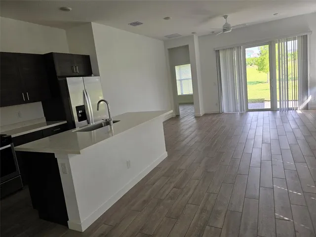a kitchen with a sink and wooden floor