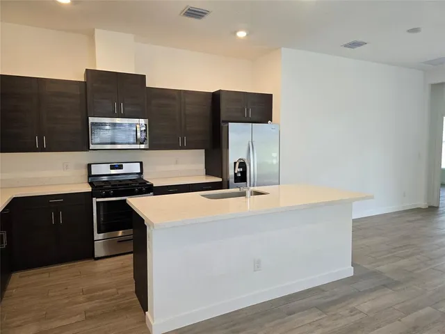 a kitchen with stainless steel appliances granite countertop a stove and a refrigerator