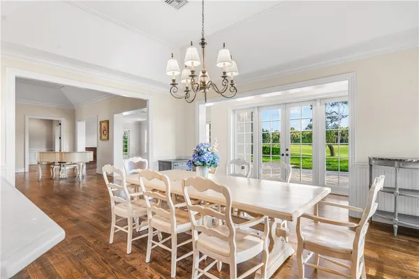a view of a dining room with furniture wooden floor and chandelier