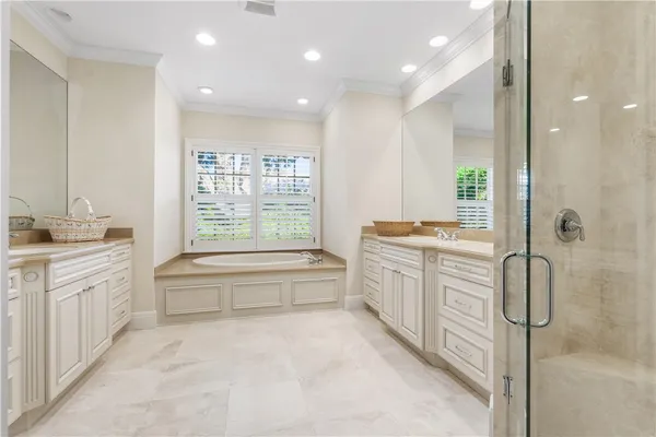 a bathroom with a granite countertop sink a large mirror and a bathtub next to a window