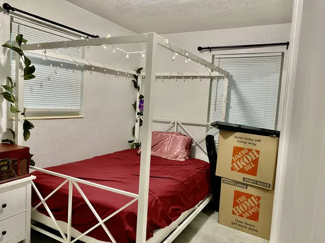 a bedroom with a bed and a flat tv screen on the table