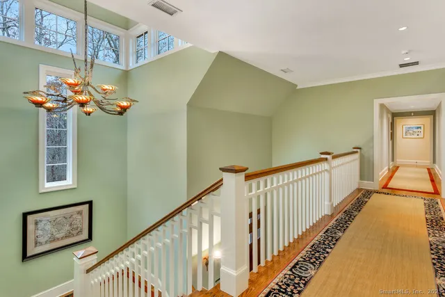 a view of staircase with railing and a chandelier