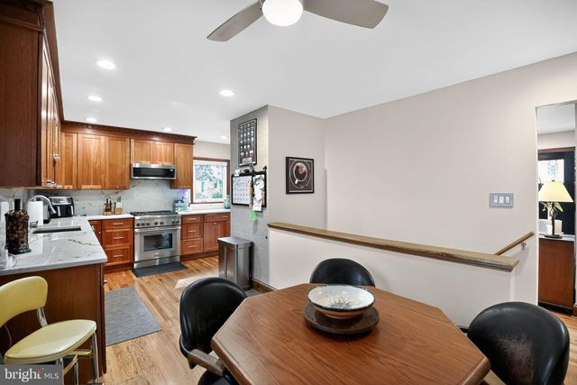 a kitchen with stainless steel appliances granite countertop a sink a stove a dining table and chairs
