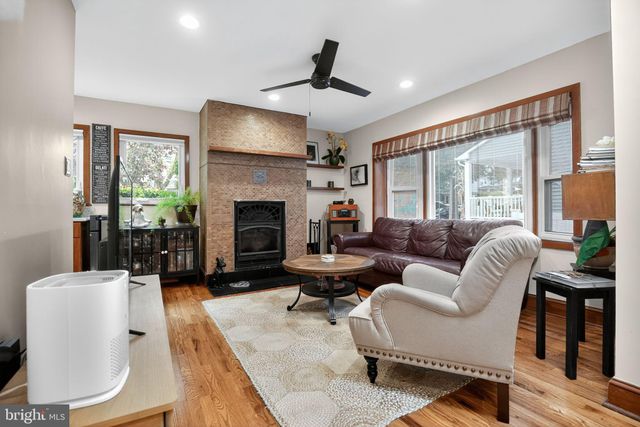 a living room with furniture fireplace and a large window