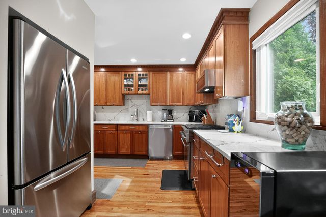 a kitchen with stainless steel appliances granite countertop a sink a stove a refrigerator and cabinets