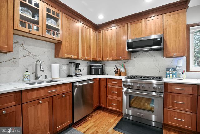a kitchen with stainless steel appliances granite countertop a sink a stove and cabinets