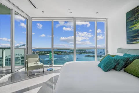 a bedroom with a bed and glass window