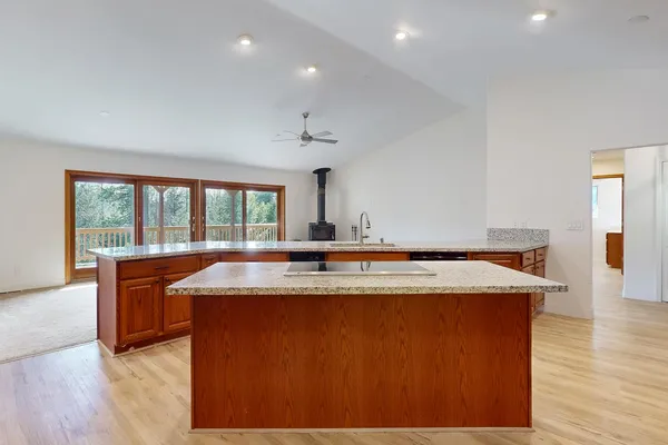 a view of a kitchen with sink a ceiling fan and a wooden floor