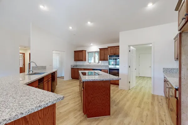 a view of a kitchen with sink a ceiling fan and a wooden floor