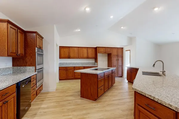 a large living room with stainless steel appliances kitchen island granite countertop a large window and a kitchen view