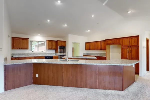 a room with kitchen island a sink and wooden floor