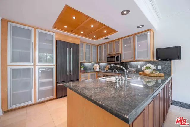 a kitchen with granite countertop a sink stainless steel appliances and cabinets