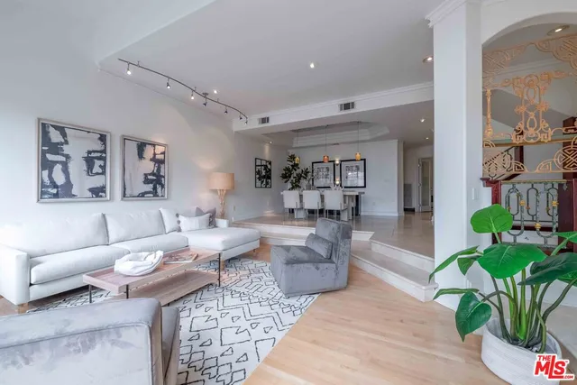 a living room with patio furniture and a potted plant