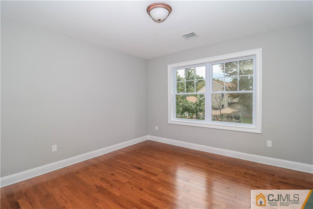 32 Windsor Road Edison, NJ 08817 - Photo 24 of 24 an empty room with wooden floor and windows