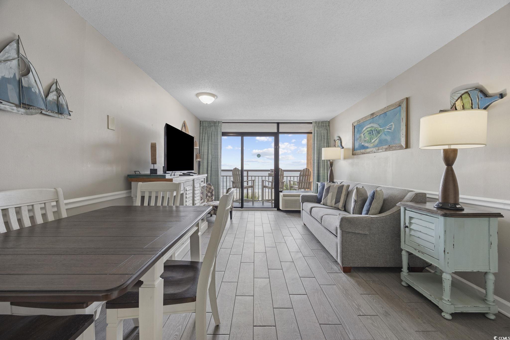 1501 South Ocean Boulevard, Unit 338 Myrtle Beach, SC 29577 - Photo 3 of 40 Dining space featuring a wall of windows, a textured ceiling, and wood look finish ceramic tile
