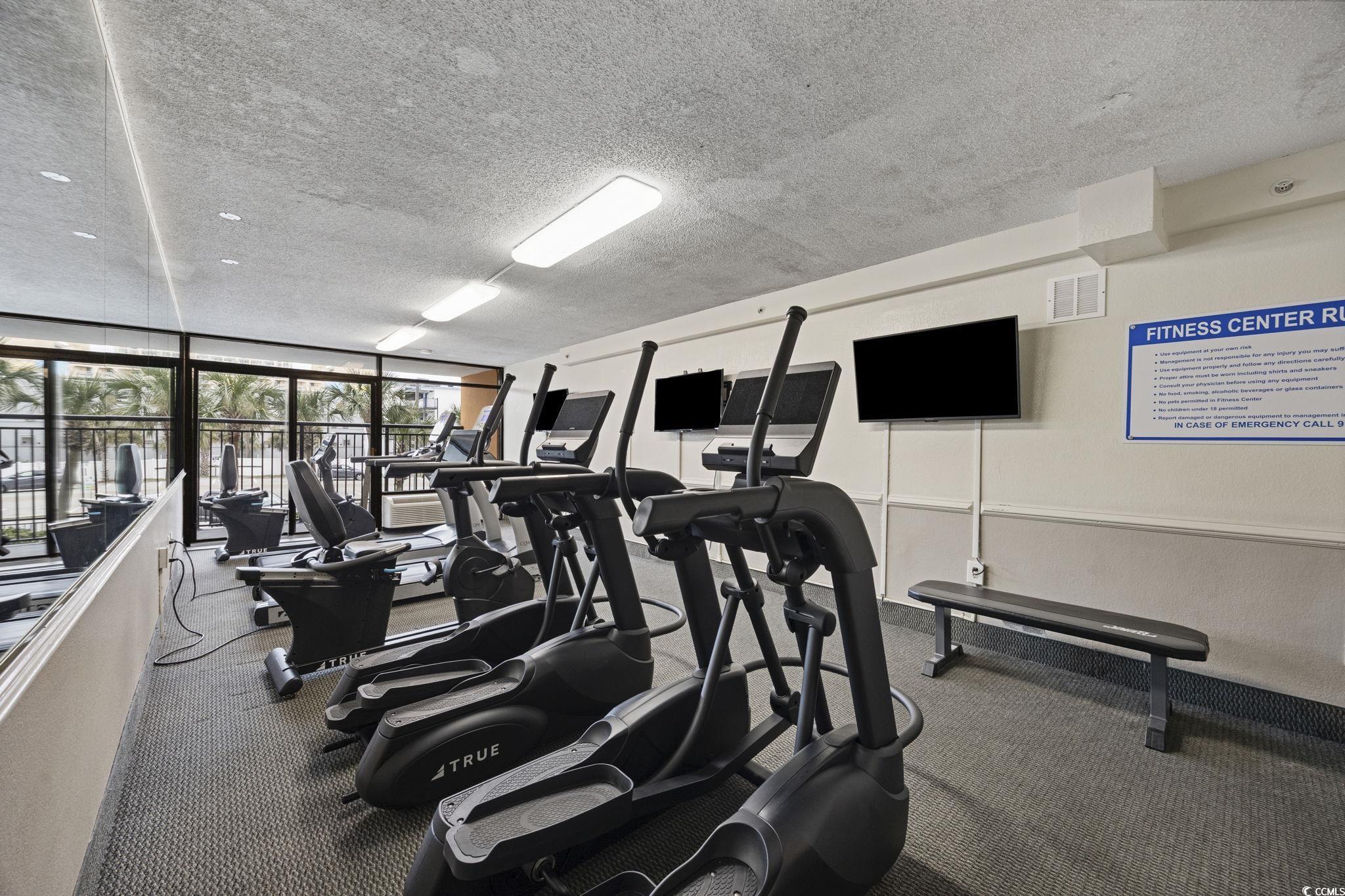 1501 South Ocean Boulevard, Unit 338 Myrtle Beach, SC 29577 - Photo 38 of 40 Gym featuring a wall of windows and a textured ceiling