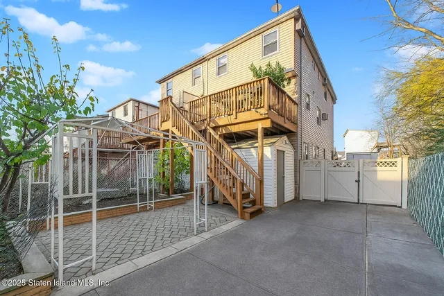 a view of a house with a small yard and wooden fence