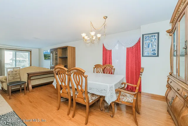 a dining room with furniture a chandelier and wooden floor