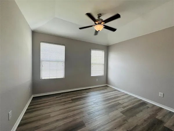 a view of a big room with wooden floor and windows