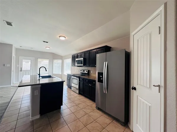 a kitchen with stainless steel appliances granite countertop a refrigerator and a sink