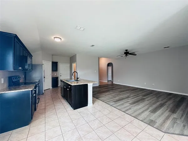a kitchen with stainless steel appliances kitchen island granite countertop a refrigerator and a stove top oven