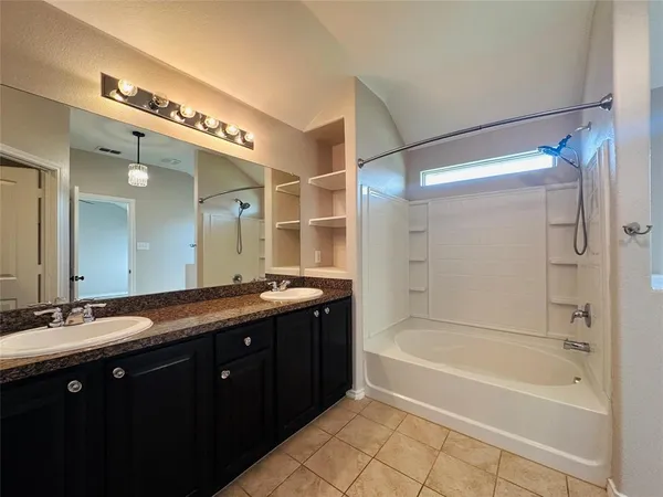 a spacious bathroom with a granite countertop tub sink shower and mirror