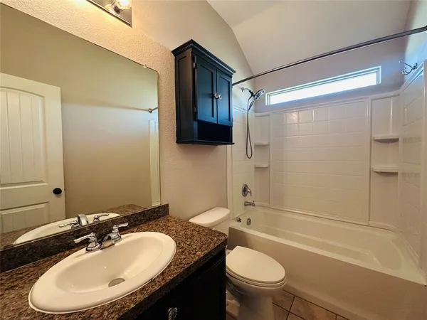 a bathroom with a granite countertop sink toilet a mirror and shower