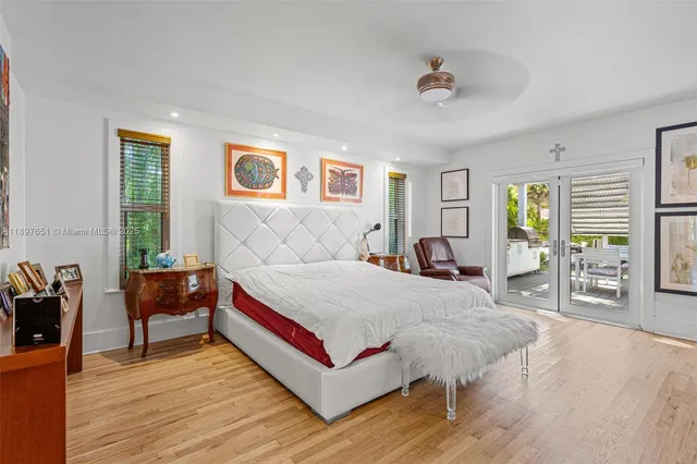 a view of a patio with table and chairs potted plants and floor to ceiling window