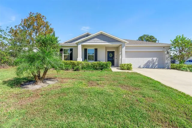 a front view of a house with yard and green space