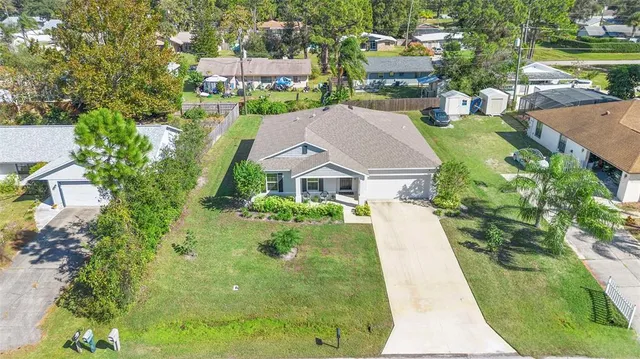 an aerial view of a house with a yard and lake
