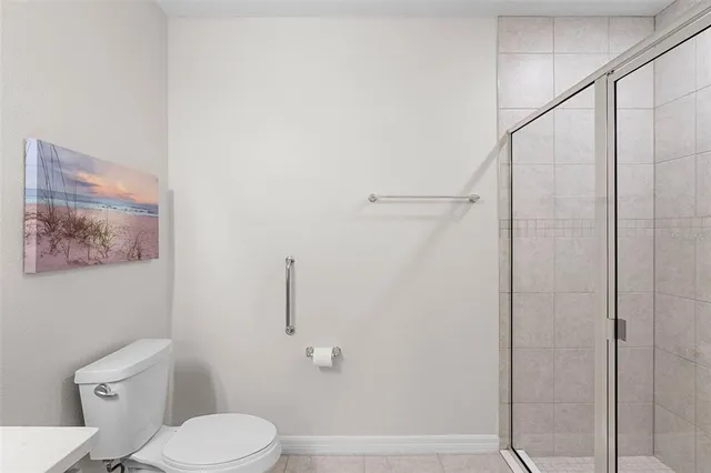 a white toilet sitting next to a shower