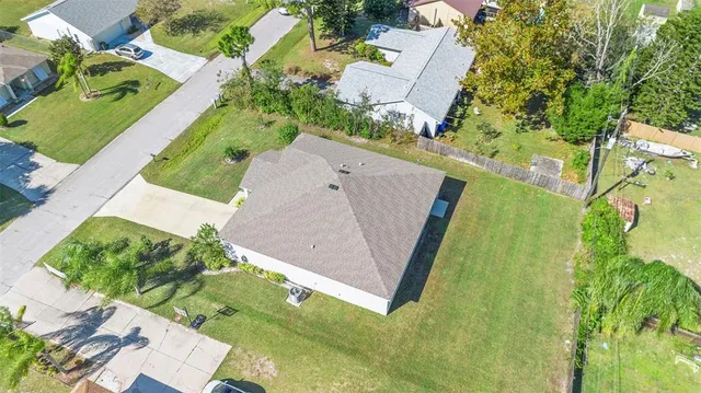 an aerial view of a house with a garden and trees