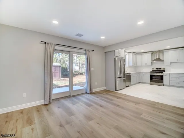 a view of kitchen with stainless steel appliances granite countertop a refrigerator and a sink