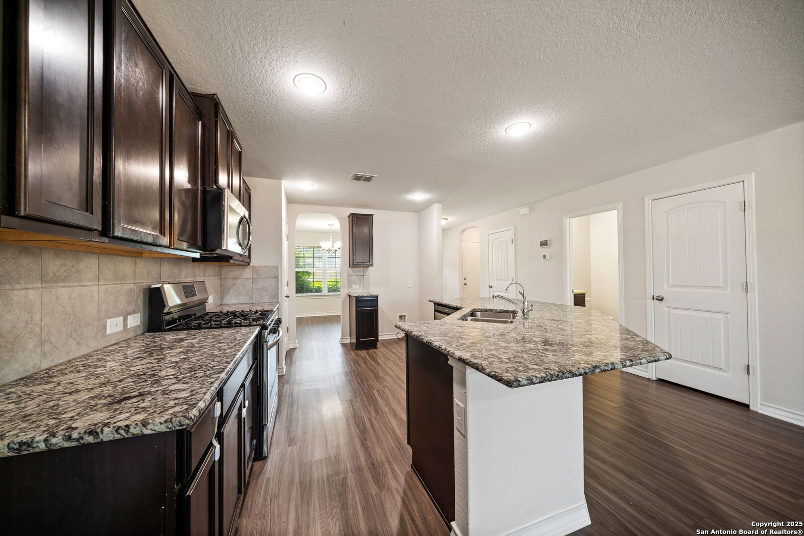 13415 Wild Rye San Antonio, TX 78254 - Photo 8 of 49 a kitchen with stainless steel appliances granite countertop lots of counter top space and wooden floor