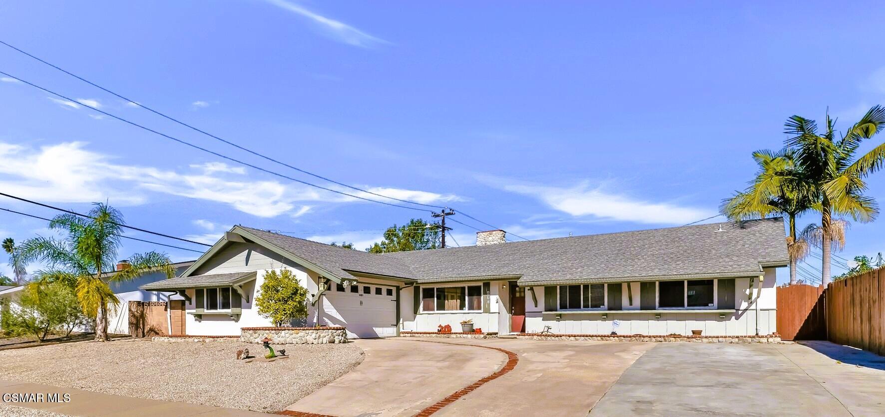 a view of the house with palm trees