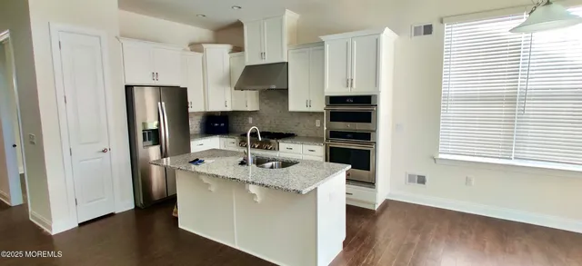 a kitchen with stainless steel appliances granite countertop a sink stove and refrigerator