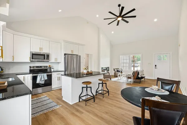 a kitchen with stainless steel appliances granite countertop a sink stove refrigerator and microwave