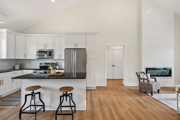 a kitchen with stainless steel appliances a dining table chairs stove microwave and cabinets