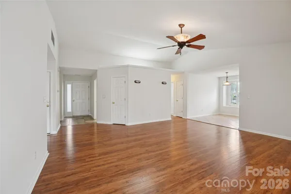 a view of empty room with wooden floor and ceiling fan