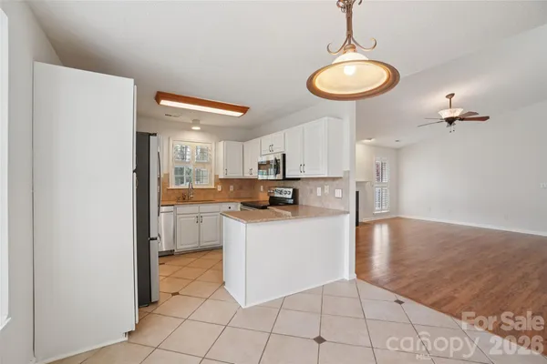 a kitchen with stainless steel appliances granite countertop a refrigerator a sink dishwasher and a stove with wooden floor