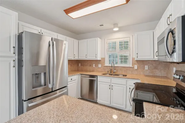 a kitchen with a refrigerator a sink and cabinets