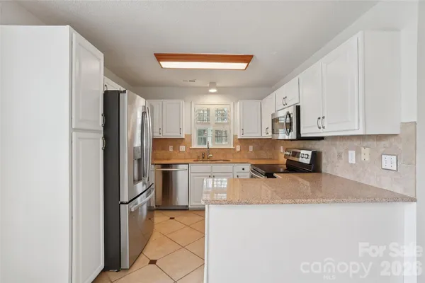 a kitchen with stainless steel appliances granite countertop a refrigerator stove microwave and sink