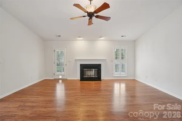 a view of an empty room with window and fireplace