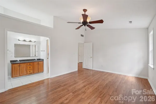a view of empty room with wooden floor and window