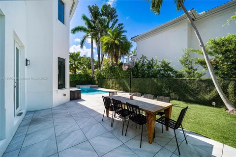 a view of a patio with table and chairs potted plants and palm tree