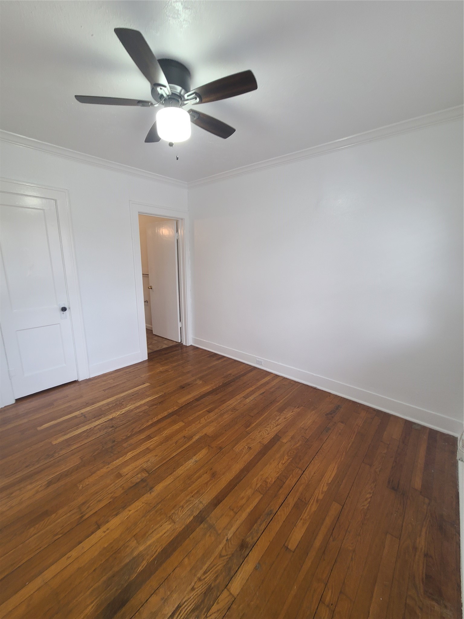 4414 Woodside Street, Unit 8 Houston, TX 77023 - Photo 11 of 14 an empty room with wooden floor and ceiling fan